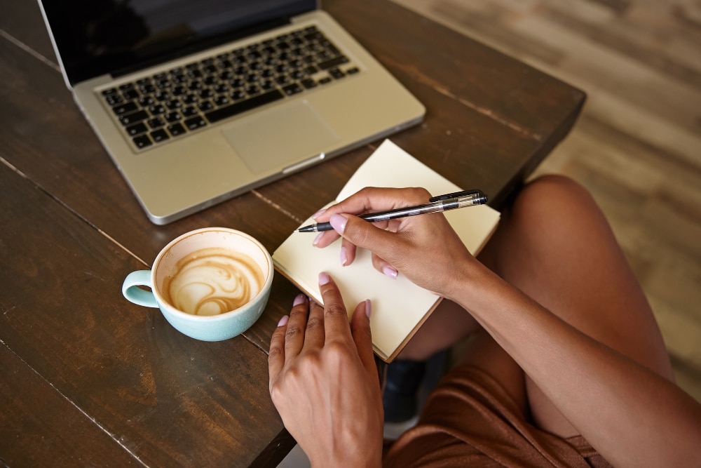 indoor close up wooden countertop with laptop it freelancer female working public place with her notebooks drinking coffee - ePlanet